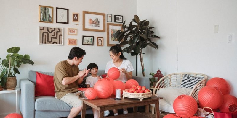 pexels-photo-9016170-9016170 Family gathering indoors decorating with red lanterns, creating a warm and festive atmosphere.